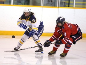 Kaylie Venedam of the College Notre Dame Alouettes and Jillian Banks of the Bear Creek Secondary School Kodiaks fight for the loose puck during OFSAA AAA/AAAA action from the McClelland Arena on Wednesday afternoon.
