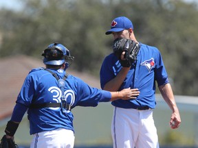 Blue Jays starter J.A. Happ talks with catcher Dioner Navarro on Wednesday. In 2.2 innings against the Philadelphia Phillies, Happ allowed three runs on three hits — a bases loaded double in the second — walked four and struck out two. (Veronica Henri/Toronto Sun)