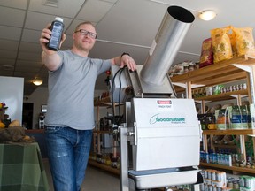 Christian Vemb, co-owner of London?s Pulp and Press Juice, shows off the cold press he uses to make trendy fruit and vegetable juices. (DEREK RUTTAN, The London Free Press)