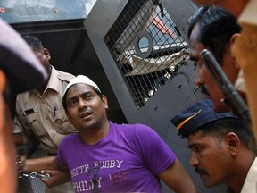 Policemen escort one of the four men convicted of raping a photojournalist outside a jail in Mumbai on March 20, 2014. (REUTERS/Mansi Thapliyal)