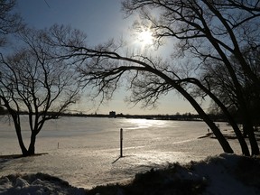 A row of trees are silhouetted framing the frozen shoreline of Little Lake on Tuesday, March 18, 2014 at Rogers Cove in Peterborough, Ont. Thursday officially marks the first day of Spring. (Clifford Skarstedt/QMI Agency)