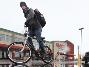 Luc Pitre drives home on his bike after getting some groceries on Merivale Road in Ottawa On. Thursday March 20,  2014. The over night snow which Ottawa received melted by midday Thursday.  Tony Caldwell/Ottawa Sun/QMI Agency