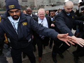 Mayor Rob Ford, surrounded by security staff, heads back to City Hall on March 19. The police had earlier released more court documents about Project Brazen 2.
Craig Robertson/Toronto Sun
