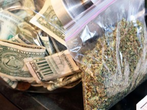 A bag of marijuana being prepared for sale sits next to a money jar at BotanaCare in Northglenn, Colorado in this file photo taken December 31, 2013. (REUTERS/Rick Wilking/Files)