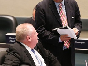 Mayor Rob Ford refuses an offer to sign Councillor Denzil Minnan-Wong's copy of Crazy Town -- a Rob Ford biography -- at a meeting of Toronto city council on Thursday. (MICHAEL PEAKE/Toronto Sun)