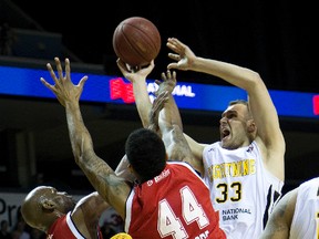 London Lightning player Greg Surmacz fights for a rebound against Quinnel Brown and George Goode of the Windsor Express. (Free Press file photo)