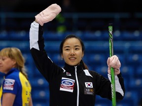 South Korea skip Kim Ji-sun waves to the crowd after defeating Sweden during her tie-breaker game at the world women's curling championship in Saint John, N.B., on Friday, March 21, 2014. (Mathieu Belanger/Reuters)