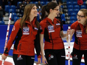 Canada's skip Rachel Homan (left), lead Lisa Weagle (centre), and second Alison Kreviazuk (right) celebrate after defeating Switzerland during their Page playoff game at the world women's curling championship in Saint John, N.B., Friday, March 21, 2014. (Mathieu Belanger/Reuters)