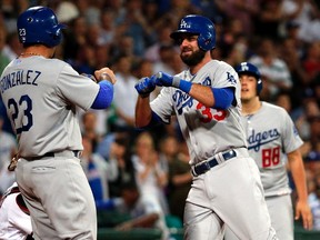 Scott Van Slyke, the early home run leader in fantasy baseball, is greeted by Adrian Gonzalez after his two-run belt in Saturday's opener in Australia. (Reuters)