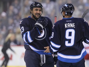 Winnipeg Jets forward Dustin Byfuglien (left) and Evander Kane talk things over during a break in play against the Carolina Hurricanes during NHL action at MTS Centre in Winnipeg, Man. on Sat., March 22, 2014. Kevin King/Winnipeg Sun/QMI Agency