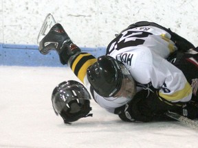 Jeff Tribe/Tillsonburg News
Tillsonburg Thunder forward Shane Balcomb ‘checks’ Komoka’s Adam Nemeth Saturday evening at the Kinsmen/Memorial Arena. Balcomb and Komoka’s Ryan Hladyniuk would pick up offsetting slashing minors following the play.