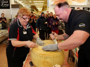 Smylie's managers Angie McCrory and Joe deWitt work to break a block of parmesan cheese into halves as part of an attempt by Loblaw stores to break a Guinness world record for the most wheels cracked simultaneously. The record was 426; staff were to try to break 1,000.