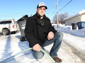 Evan Fuller is seen behind his Transcona property on Sun., March 24, 2014. The construction worker took it upon himself to hook up a temporary water line at a willing neighbour's home but was surprised to learn the city is refusing to reimburse him. (Kevin King/Winnipeg Sun)