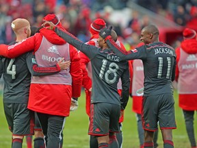 Toronto FC players Michael Bradley (left), Jermain Defoe and Jackson celebrate after defeating D.C. United in the home opener at BMO Field. (JACK BOLAND/Toronto Sun)