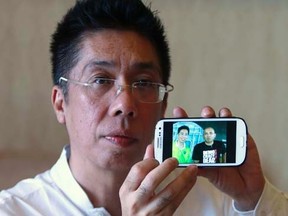Peter Chong holds up his smartphone to show a photo of himself with missing Malaysia Airlines Flight MH370 captain Zaharie Ahmad Shah during an interview with Reuters at a hotel in Sepang March 18, 2014.    REUTERS/Samsul Said