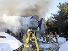 Fire crews battle flames raging in a home at 109 Topol in the West Ottawa community of Carp on Sunday, March 24, 2014. A 13-year-old boy suffered smoke inhalation in the $1-million fire. (OTTAWA FIRE SERVICE Scott Stillborn)