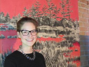 Sonya Blazek, a curatorial assistant at the Thames Art Gallery, poses with the 2011 work of artist Lindsay Beaubien entitled Carmine Marsh. The charcoal and acrylic creation is among the pieces of art that are now part of the gallery's digital collection.