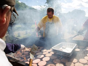 Mike Scott flips burgers with Local 30 member Rudi Haak, left, during the Labour Day BBQ at Giovanni Caboto Park in Edmonton, Alberta on Monday, September 3, 2012. (EDMONTON SUN FILE)