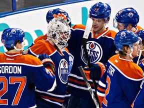 Oilers goalie Ben Scrivens is swarmed by his teammates following his 59-save shuitout performance against the San Jose Sharks on Jan. 29. (Codie McLachlan, Edmonton Sun)