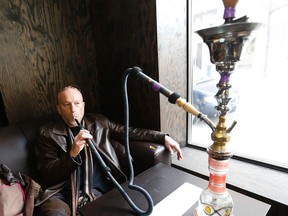 Mike Strobel tries hookah at the Ali Baba lounge on Dundas St. W. on Monday, March 24, 2014. (Michael Peake/Toronto Sun)