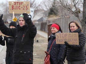 Michael Stoesser, 26, was one of the organizers behind a demonstration outside MP Pat Davidson's Sarnia, Ont. office Tuesday March 25, 2014, protesting Bill C-23. About seven people with signs and Canadian flags set up along Finch Drive, protesting the Fair Elections Act. The last-minute rally in Sarnia was organized to coincide with similar demonstrations at Conservative MP offices across the country, Stoesser said. The controversial bill takes away voting rights from vulnerable populations, boosts the limits on political donations and campaign spending, and shifts powers away from Elections Canada, group members said. TYLER KULA/ THE OBSERVER/ QMI AGENCY