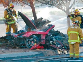 Firefighters extinguish the fire in the car where actor Paul Walker was killed along with another unidentified man during a car crash in Valencia, Santa Clarita, California, November 30, 2013. (REUTERS/Dan Watson/The Santa Clarita Valley Signal/Handout)