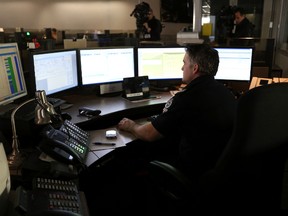 Police and civilians answer calls in the 911 centre at the downtown police headquarters in Edmonton, Alberta. Edmonton Sun