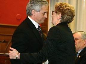 Premier Kathleen Wynne hugs MPP Bill Mauro after his swearing-in ceremony as minister of municipal affairs and housing at Queen's Park in Toronto Tuesday, March 25, 2014. (Craig Robertson/Postmedia Network)