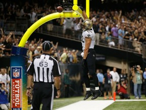 Saints tight end Jimmy Graham dunks the ball over the goal post after scoring a touchdown against the Dolphins in New Orleans on Sept. 30, 2013. (Chris Graythen/Getty Images/AFP)