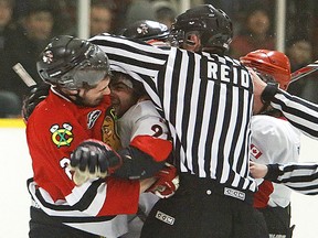 Linesman Sean Reid enters the fray as tempers flare during Schmalz Cup quarterfinal action between the Picton Pirates and Lakefield Chiefs Tuesday night in Lakefield. (CLIFFORD SKARSTEDT/QMI Agency)