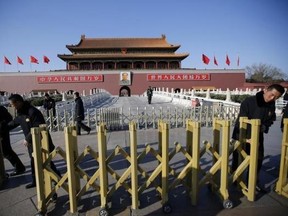 Security guards set up a fence in front of the portrait of China's late leader Mao Zedong at the main entrance of the Forbidden City near the Great Hall of the People where the National People's Congress (NPC) is taking place in Beijing March 6, 2014. (Reuters/Kim Kyung-Hoon)