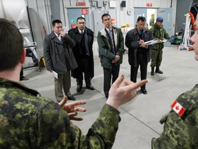 Officials from the Philippines Government, two with the Department of Foreign Affairs and the others with the Armed Forces familiarize themselves with Canada's Disaster Assistance Response Team (DART) during a tour of the High Readiness Detachment (warehouse) at 8 Wing/CFB Trenton, Ont. Wednesday, March 26, 2014. - JEROME LESSARD/THE INTELLIGENCER/QMI AGENCY
