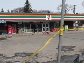 Police evidence markers are seen in the parking lot of a 7-11 on Main Street at Bannerman Avenue in Winnipeg, Manitoba, Canada, Wednesday, March 26, 2014. Three victims were stabbed early Wednesday morning and transported to hospital, where they were listed in stable condition. (Jim Bender/Winnipeg Sun/QMI Agency)
