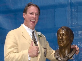 Pro Football Hall of Fame enshrinee Jim Kelly poses with his bust during the enshrinement ceremony in this August 3, 2002 file photo. (AFP)
