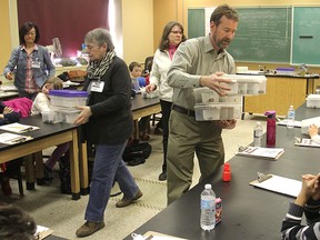 Ann Blake, left front, director of the Kingston Association of Museums, Galleries and Historic Sites, helps curator Mark Badham hand out boxes of minerals to students as they participate in Beyond Classrooms, an educational pilot project that moved their classroom to the Miller Museum of Geology for a week, in Kingston, Ont. on Wednesday. 
MICHAEL LEA\THE WHIG STANDARD\QMI AGENCY.