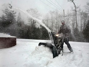 Doug Cook operates snow blower as he clears his driveway during a major snow storm in Enfield, Nova Scotia March 26, 2014. A late season blizzard brought heavy snow and high winds blanketing the province. (REUTERS/Darren Pittman)