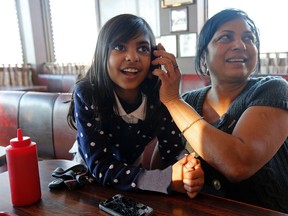 Alina Rahim, 8, listens to Mayor Rob Ford shortly after the televised debate on March 26, 2014 while her grandmother Sherry Jurakhan holds the phone at the Steak Queen on Rexdale Blvd. (Michael Peake/Toronto Sun)