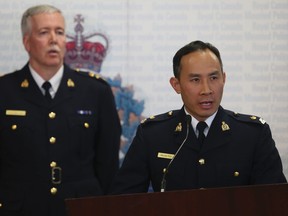 RCMP Insp. Henry Tso (R) and Supt. Dave Bellamy (background) speak to media in Toronto about a fraudulent investment investigation, Wednesday, March 26, 2014. Jack Boland/QMI Agency