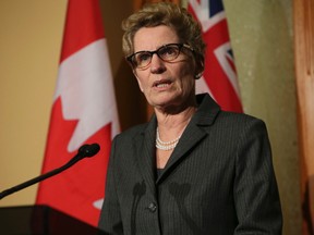Ontario Premier Kathleen Wynne emerges from her Queen's Park office and reads a prepared statement to the media over the gas plant allegations Thursday, March 27, 2014. (Jack Boland/Toronto Sun)