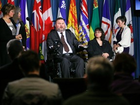 Conservative MP Steven Fletcher, centre, speaks during a news conference regarding his two private member's bills dealing with physician-assisted suicide, on Parliament Hill on March 27, 2014. (REUTERS/Chris Wattie)