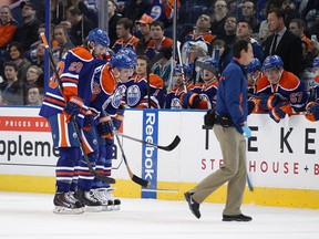Oilers trainers help Ryan Jones off the ice after he was hit by a puck while trying to block a shot. (Ian Kucerak, Edmonton Sun)