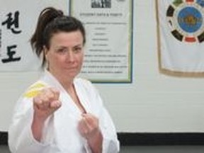 Cathy Hadubiak proudly flaunts her third degree black belt. She began 
practicing taekwondo as an adult after her children took up the martial art form