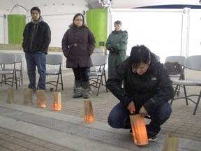 Melissa Jack lights a candle for one of the 26 aboriginal women who have gone missing from the Treaty 3 area at a memorial on Thursday, March 27.