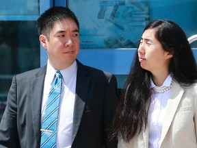 Matthew and Grace Huang, a U.S. couple who were accused of murdering their adopted daughter Gloria, stand outside the entrance of the Court of First Instance after their trial in Doha, March 27, 2014. (REUTERS/Mohammed Dabbous)