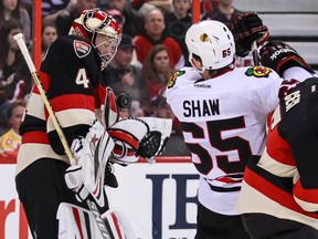 Ottawa Senators' netminder Craig Anderson makes a glove save as Cody Ceci checks Chicago Blackhawks' Andrew Shaw during NHL hockey action at the Canadian Tire Centre in Ottawa, Ontario on Friday March 28, 2014. Errol McGihon/Ottawa Sun/QMI Agency