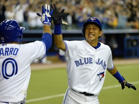 Blue Jays shortstop Munenori Kawasaki celebrates with catcher Dioner Navarro after scoring the winning run in the ninth inning against the New York Mets at the Olympic Stadium on Friday. (Eric Bolte-USA TODAY Sports)