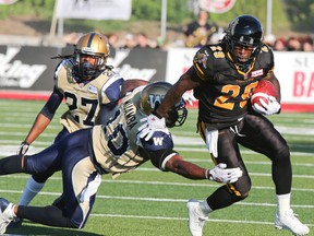 Former Hamilton Tiger-Cats Chevon Walker breaks from Winnipeg Blue Bombers Henoc Muamba at Alumni Field in Guelph, Ont. on Sat. July 14,2013.  Dave Thomas/Toronto Sun/QMI Agency