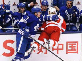 Toronto Maple Leafs captain Dion Phaneuf slams Detroit Red Wings' centre Johan Franzen into the bench at the Air Canada Centre Saturday, March 29, 2014. (Stan Behal/Toronto Sun)