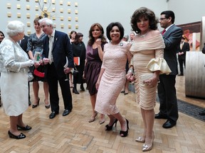 Actress Joan Collins (R), singer Shirley Bassey (C) and actress Kate O'Mara (L) joke as they wait to meet Britain's Queen Elizabeth II during her visit to the Royal Academy of Arts in central London on May 23, 2012. AFP PHOTO / POOL /CARL COURT
