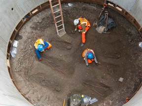 Archaeologists work on unearthed skeletons in the Farringdon area of London in this undated handout photograph released March 15, 2013. (REUTERS/Crossrail/Handout)